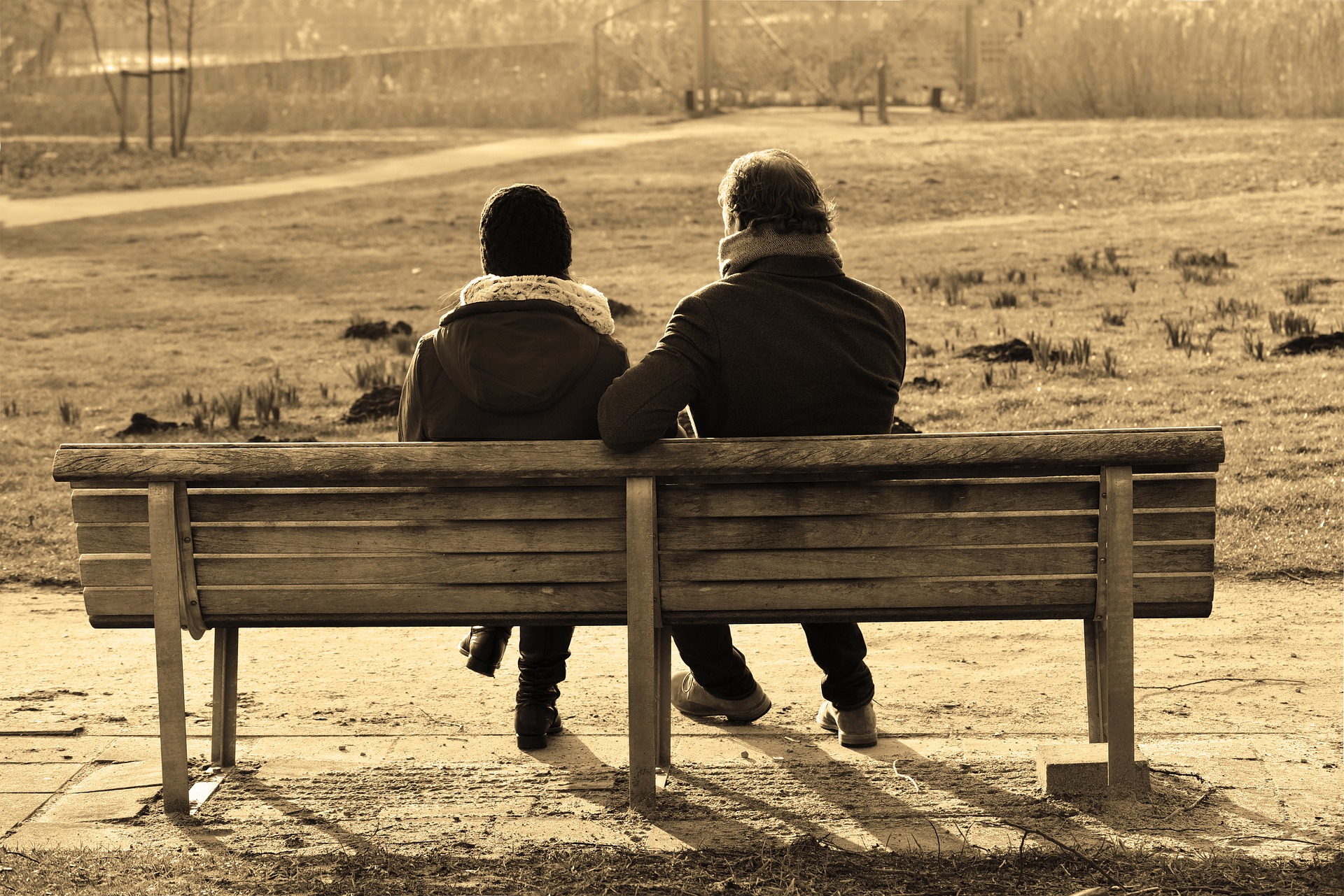 Couple conversing on a wooden bench